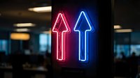 Red and blue neon arrow signs pointing upward in modern office environment for business growth and direction concepts.