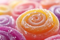 Colorful fruit jelly candies with sugar coating in spiral shapes, sweet confectionery treats for dessert and snack concepts.