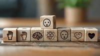 Wooden cube blocks with emotional intelligence and empathy symbols including facial expressions, heart, brain and hands arranged in row on wooden surface.
