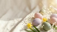Pastel colored Easter eggs with spring flowers and baby's breath on soft white linen fabric creating elegant holiday decoration for seasonal celebrations.