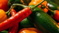 Fresh colorful chili peppers mix with red and green hot peppers for cooking spicy food and seasoning dishes.