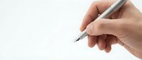 Hand holding silver pen ready to write on clean white background for business documents and professional correspondence.