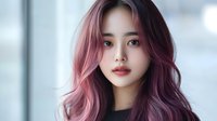 Young Asian woman with trendy pink and purple ombre hair color looking at camera. Soft natural makeup, glossy lips and flawless skin. Modern beauty and hair coloring concept.