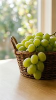 Fresh green grapes overflowing from woven basket on wooden table with sunlit window background, perfect for food and lifestyle designs.