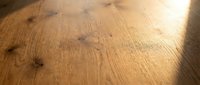 Natural oak wood flooring with visible grain patterns and knots creating warm texture for interior design and home renovation projects.