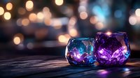 Glowing glass candle holders in blue and purple colors on wooden surface with blurred bokeh lights background creating magical atmosphere.