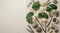 Natural spa wellness flat lay with tropical monstera leaves, bamboo sticks, smooth stones and eucalyptus on neutral beige background for relaxation.