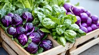 Fresh purple cabbage and green lettuce arranged in wooden crates at farmers market, organic produce display with vibrant colors and textures for healthy eating.