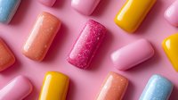 Colorful nail polish bottles scattered on pink background showcasing vibrant manicure colors for beauty and cosmetic design projects.