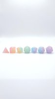 Polyhedral dice set with gradient pastel colors ranging from pink to purple, isolated on white background. Suitable for tabletop gaming, RPG, and design projects.