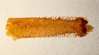 Golden orange watercolor brush stroke on textured paper with rough edges and artistic paint texture for creative design projects.