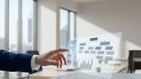 Modern businessman in dark suit reviewing financial charts and data analytics on transparent digital display in bright office environment with natural window light.