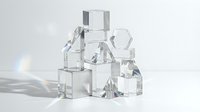 Stacked transparent glass cubes and geometric shapes arranged in abstract composition with light refraction and shadows on white background.