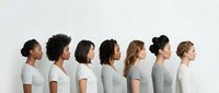 Diverse group of women with different ethnicities and hairstyles standing in profile against white background, wearing casual gray and white t-shirts, representing unity and diversity.