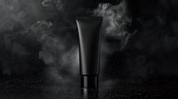 Black cosmetic tube on dark background with smoke and glitter effects, luxury skincare packaging mockup for premium beauty product advertising and branding.