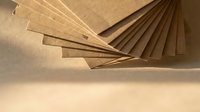 Brown cardboard sheets fanned out in artistic arrangement showing texture and layers for packaging design and craft projects.