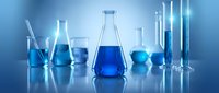 Laboratory glassware with blue chemical solutions on reflective surface. Scientific research equipment including beakers, flasks and test tubes for experiments.