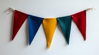 Colorful felt pennant banner with red, blue, yellow and green triangular flags hanging on string against white wall, party decoration for celebrations.
