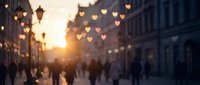 Blurred city street at sunset with glowing heart bokeh lights and silhouettes of people walking, evoking romance and Valentine's Day mood.
