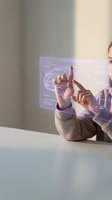 Professional businessman interacting with futuristic holographic interface displaying data analytics and digital charts in modern office environment.