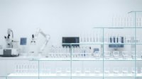 Modern laboratory interior with glass shelving displaying test tubes and scientific equipment for research and medical analysis.