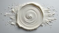 White cream cosmetic swirl with dynamic splash creating elegant spiral pattern on clean background for skincare and beauty product design.