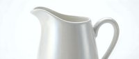 White ceramic pitcher with elegant curved handle isolated on clean background for kitchen and dining design projects.