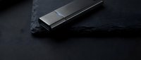 Modern metallic USB flash drive on dark slate surface with dramatic lighting for technology and data storage concepts.