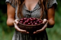 Woman holding wicker basket full of fresh red cherries outdoors in natural garden setting for healthy eating and organic farming concepts.