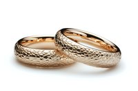 Pair of rose gold wedding bands with textured snake skin pattern surface on white background, luxury jewelry photography for marriage ceremony.