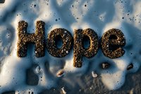 Word hope written with coffee grounds on reflective surface with water drops and dramatic lighting creating inspiring mood and texture.