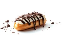 Fresh eclair filled with vanilla cream and topped with white chocolate glaze, dark chocolate drizzle and chocolate shavings on white background.