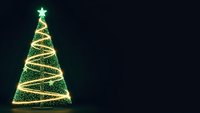 Glowing Christmas tree with golden spiral lights and green star on dark background for holiday greeting cards and festive decorations.