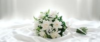 Elegant white wedding bouquet with roses and greenery on silk fabric, bridal flowers arrangement for ceremony and celebration photography.