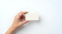 Hand holding blank white business card mockup on clean background for branding and corporate identity design projects.