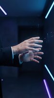 Businessman hands reaching forward in futuristic neon lit environment with blue and purple lighting effects for technology and innovation concepts.