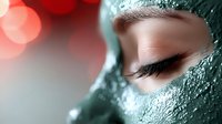 Young woman with closed eyes wearing green clay face mask for skincare routine and spa treatment relaxation.