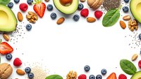 Healthy superfood frame with avocado, berries, nuts and seeds on white background. Nutritious organic ingredients for clean eating and wellness lifestyle.