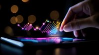 Financial data visualization on digital tablet screen with glowing charts and graphs in dark environment with bokeh lights and hand touching display.