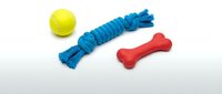 Colorful dog toys set featuring a yellow tennis ball, blue rope chew toy, and red rubber bone on a light background for pet care.