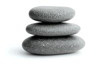 Stack of three smooth grey zen stones on white background, balanced in harmony for spa, meditation and wellness concepts. Isolated with soft shadow.