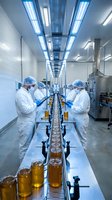 Pharmaceutical workers in sterile white suits inspecting honey production line in modern factory with blue LED lighting and quality control equipment.