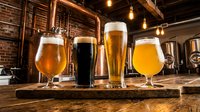 Variety of craft beers in glasses displayed on wooden board at rustic pub or brewery bar with warm lighting and brick walls, suitable for beverage, hospitality and restaurant marketing.