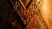 Brown leather texture with detailed stitching and seams showing craftsmanship. Close-up macro photography of natural material surface for fashion design projects.