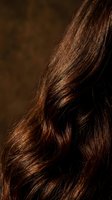 Luxurious brown hair with rich copper highlights flowing in soft waves, showcasing healthy shine and natural texture for beauty and haircare concepts.