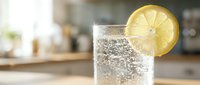 Sparkling water with fresh lemon slice garnish in clear glass, refreshing beverage for summer drinks, cocktails, and healthy hydration concepts.
