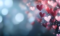 Romantic glowing hearts with sparkles floating on blurred blue background. Soft bokeh effect creates dreamy atmosphere for Valentine's Day or wedding designs.