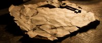 Vintage aged parchment paper with old skeleton key on wooden surface creating mysterious antique atmosphere for historical documents and treasure maps.