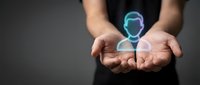 Hands holding glowing digital human avatar icon representing customer service, user profile, personal assistance and modern technology solutions.