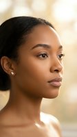 Young African American woman with natural makeup and elegant pearl earrings in soft golden light for beauty and skincare campaigns.